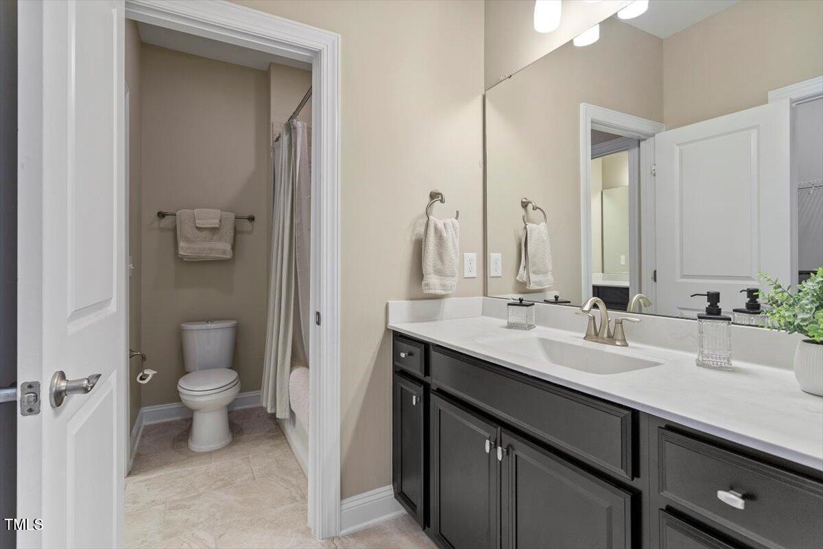 2421 Trenton Park Lane Raleigh, NC 27607 - Photo 52 of 66 a bathroom with a double vanity sink toilet and a mirror