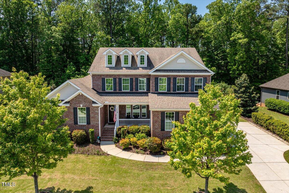 2421 Trenton Park Lane Raleigh, NC 27607 - Photo 56 of 66 a front view of a house with a yard and fountain in middle