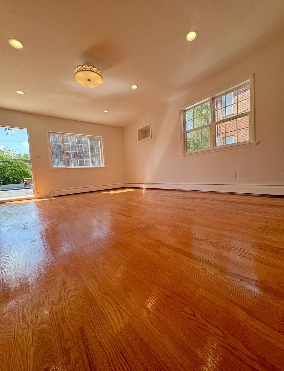 104-65 Springfield Boulevard Queens, NY 11429 - Photo 14 of 23 an empty room with wooden floor and windows