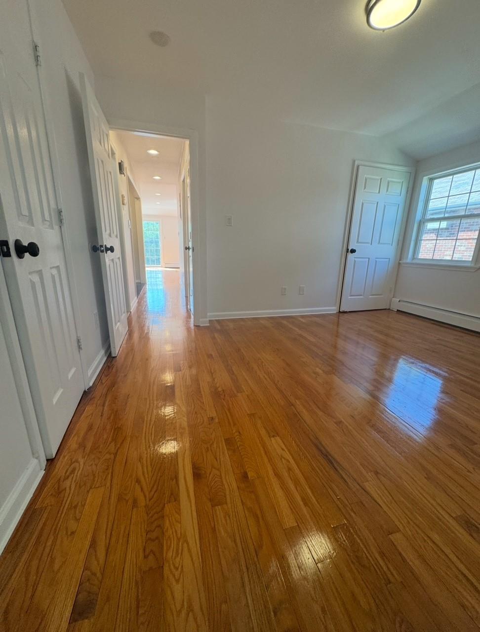 104-65 Springfield Boulevard Queens, NY 11429 - Photo 20 of 23 an empty room with wooden floor and windows