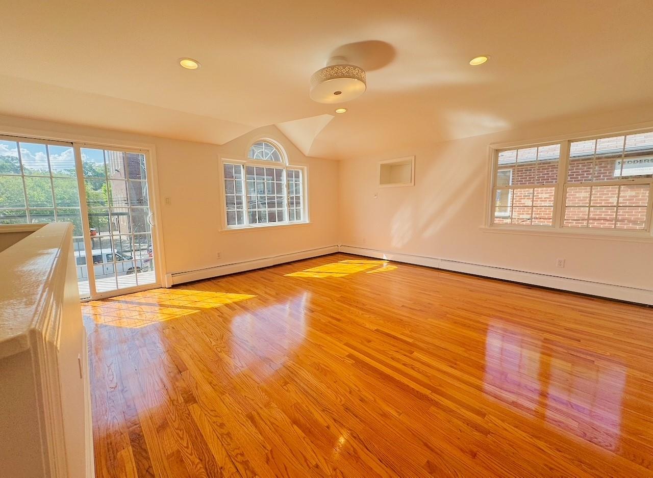 104-65 Springfield Boulevard Queens, NY 11429 - Photo 2 of 23 a view of an empty room with wooden floor and a window