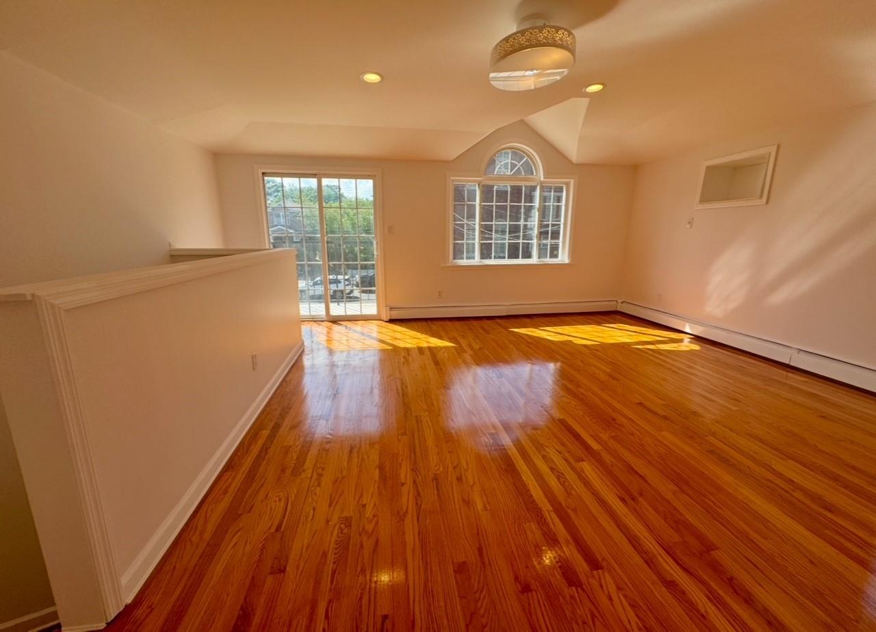 104-65 Springfield Boulevard Queens, NY 11429 - Photo 7 of 23 wooden floor in an empty room with a window