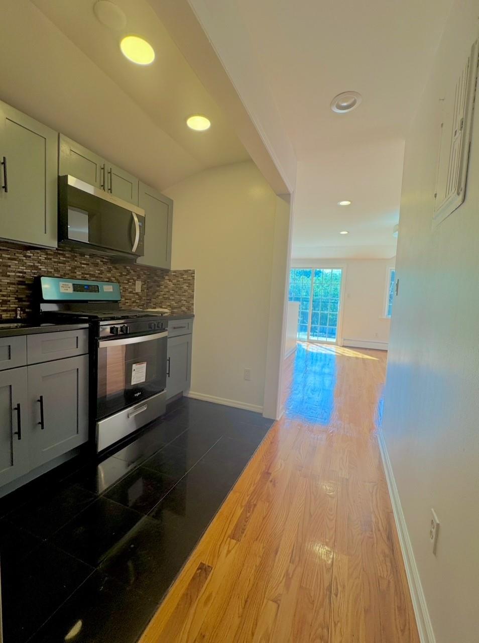 104-65 Springfield Boulevard Queens, NY 11429 - Photo 10 of 23 a open kitchen with stainless steel appliances granite countertop a stove and a wooden floors