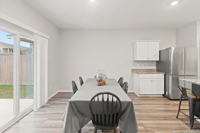a kitchen with a table chairs a stove and a refrigerator
