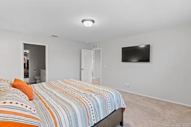 a bedroom with a bed and a flat screen tv