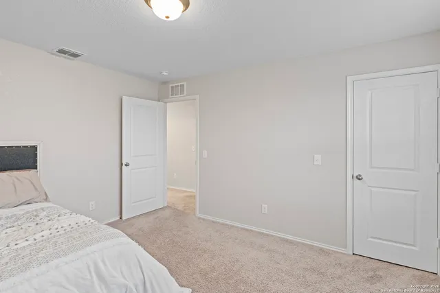 a bedroom with a bed and a chandelier fan