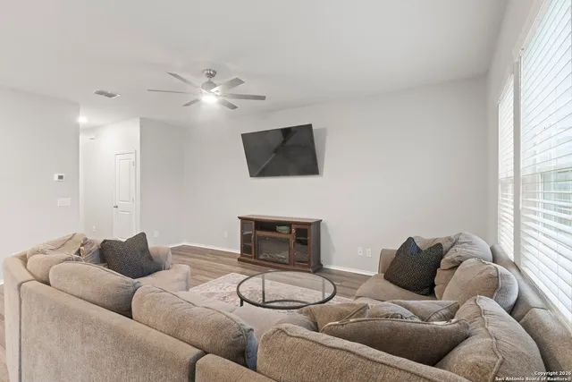 a living room with furniture a ceiling fan and a window