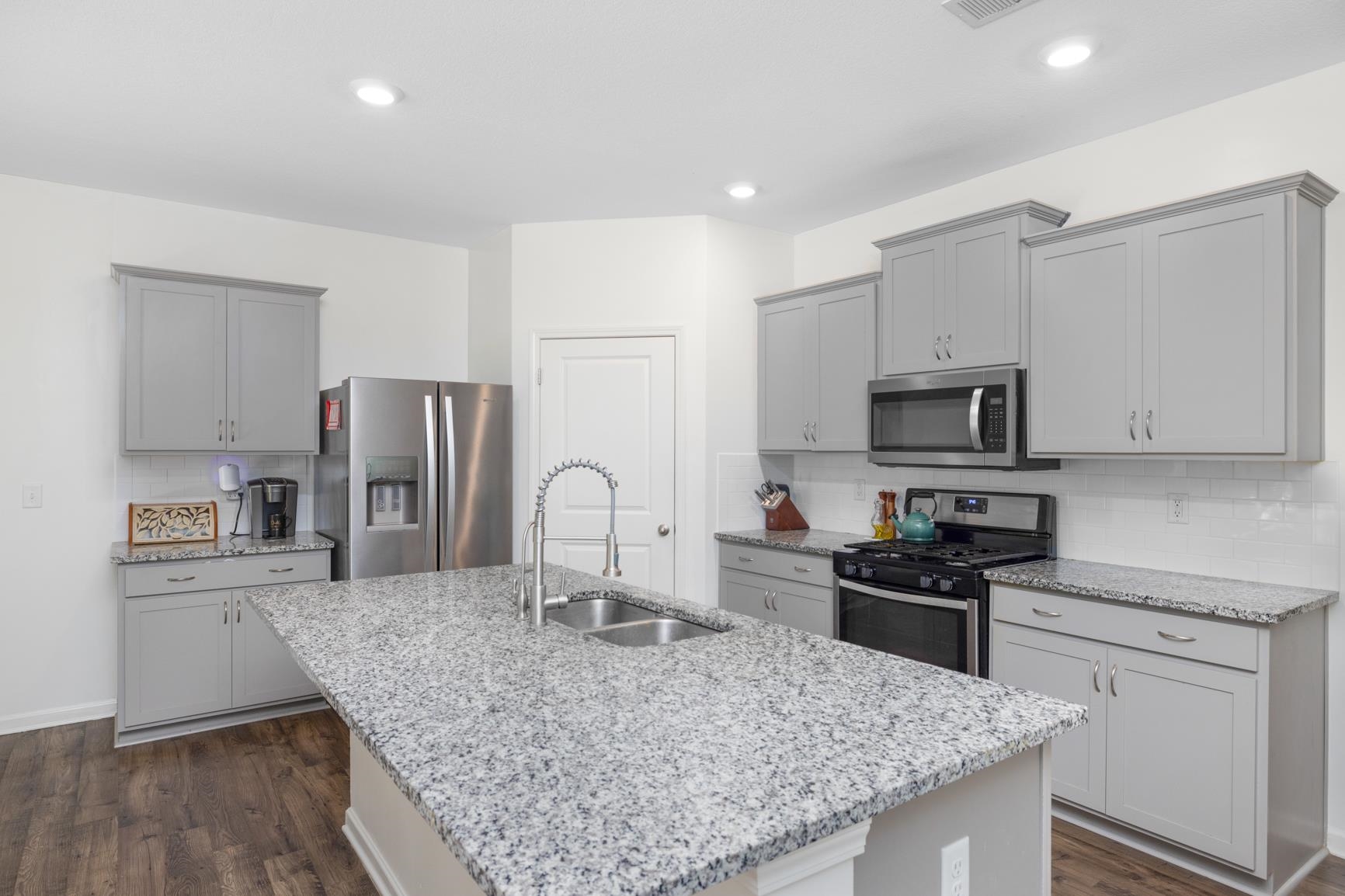5132 Shellback Drive Millington, TN 38053 - Photo 8 of 24 a kitchen with stainless steel appliances granite countertop a stove top oven a sink and dishwasher