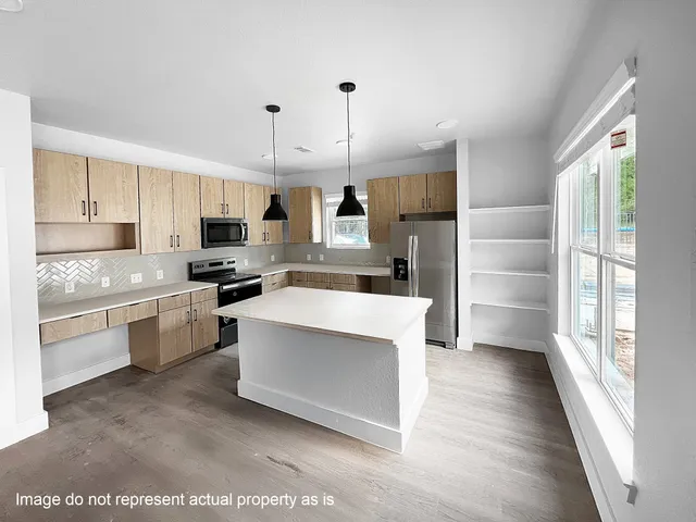 a kitchen with granite countertop a stove top oven a sink dishwasher a refrigerator and white cabinets with wooden floor