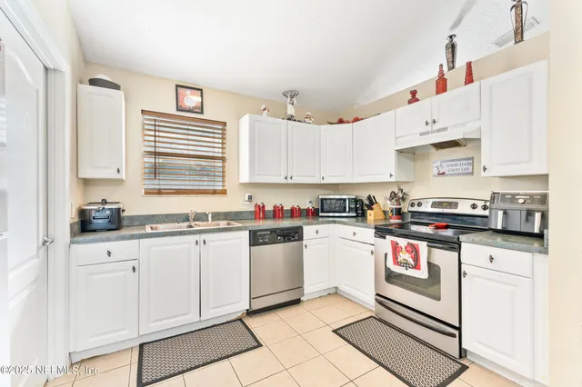 a kitchen with granite countertop white cabinets and white appliances