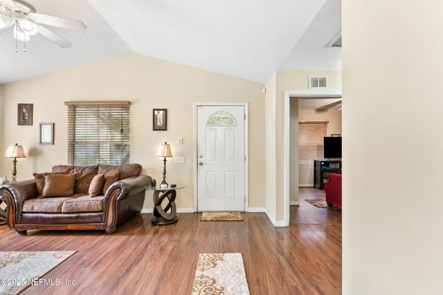 a living room with furniture and a wooden floor