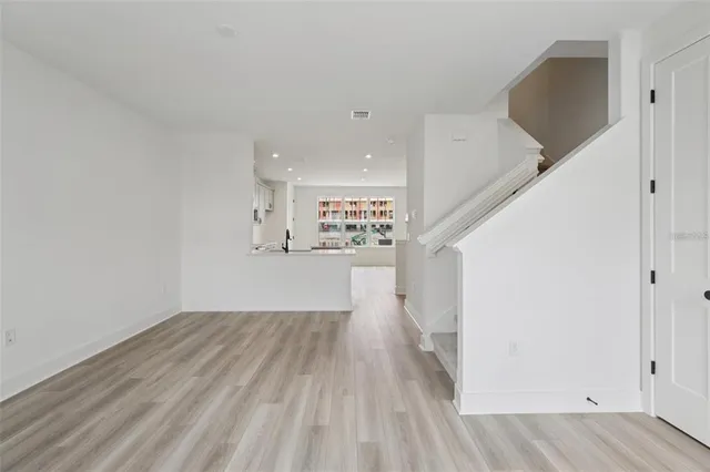 a view of a hallway with wooden floor and entryway
