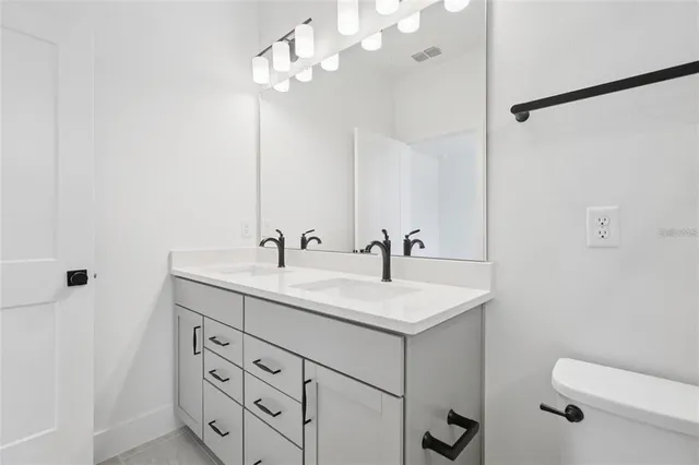 a bathroom with a sink a toilet and a mirror