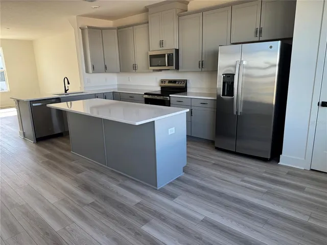 a kitchen with stainless steel appliances a refrigerator sink and microwave