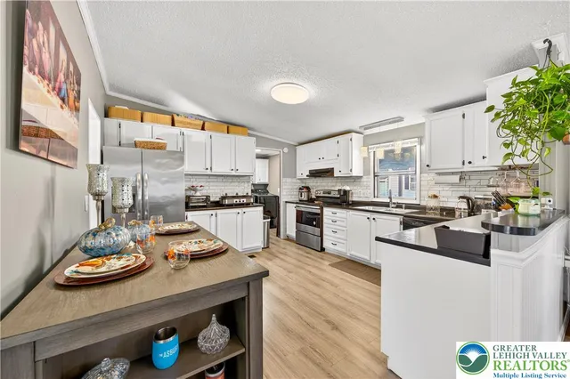 a kitchen with a refrigerator a stove a sink dishwasher and white cabinets with wooden floor