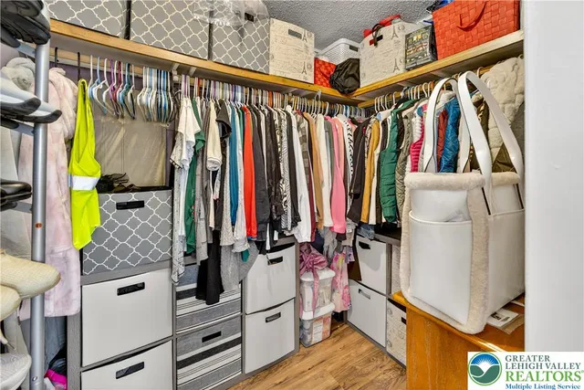 a view of walk in closet with clothes and shoes