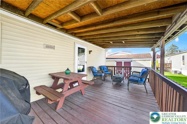 a roof deck with a table and chairs and wooden floor