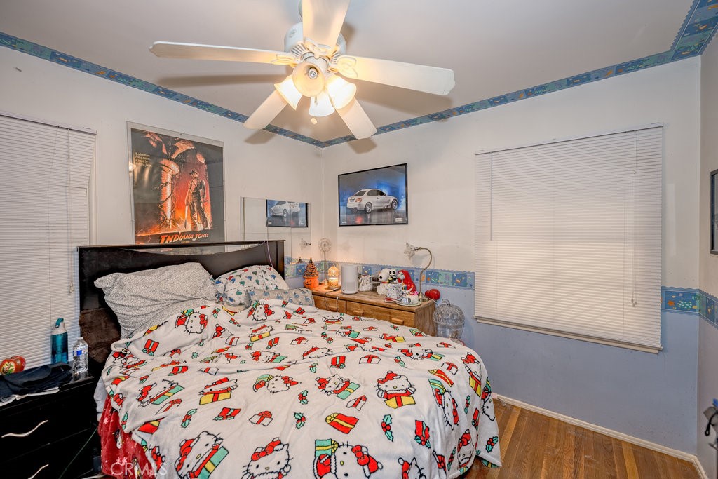 17654 Welby Way Van Nuys, CA 91406 - Photo 12 of 26 a bedroom with a large bed and a chandelier