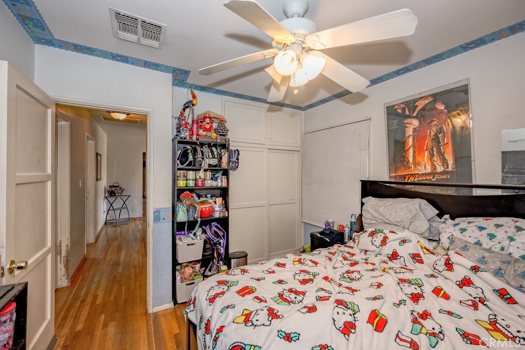 17654 Welby Way Van Nuys, CA 91406 - Photo 13 of 26 a bedroom with a bed and a chandelier