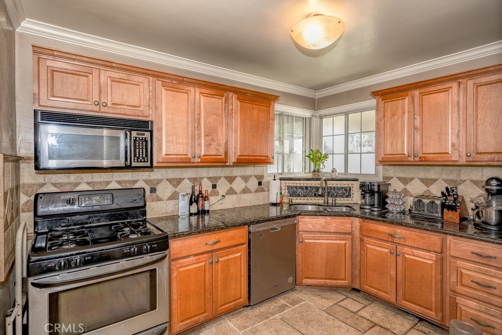 17654 Welby Way Van Nuys, CA 91406 - Photo 7 of 26 a kitchen with stainless steel appliances a stove sink microwave and cabinets