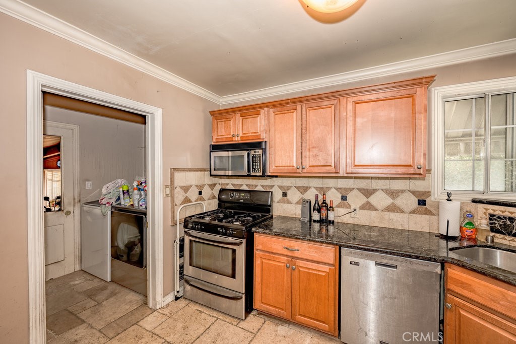 17654 Welby Way Van Nuys, CA 91406 - Photo 8 of 26 a kitchen with granite countertop a stove a sink and a refrigerator
