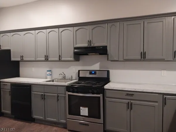 a kitchen with granite countertop white cabinets and a stove