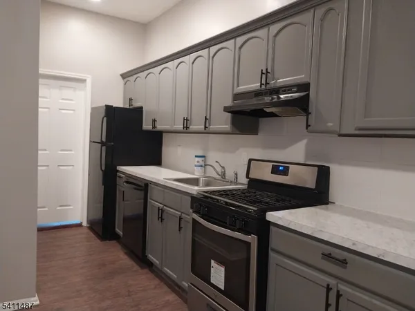 a kitchen with stainless steel appliances granite countertop a stove a refrigerator and a cabinets