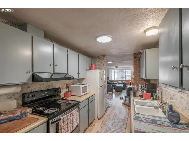 a kitchen that has a lot of cabinets a sink and appliances in it