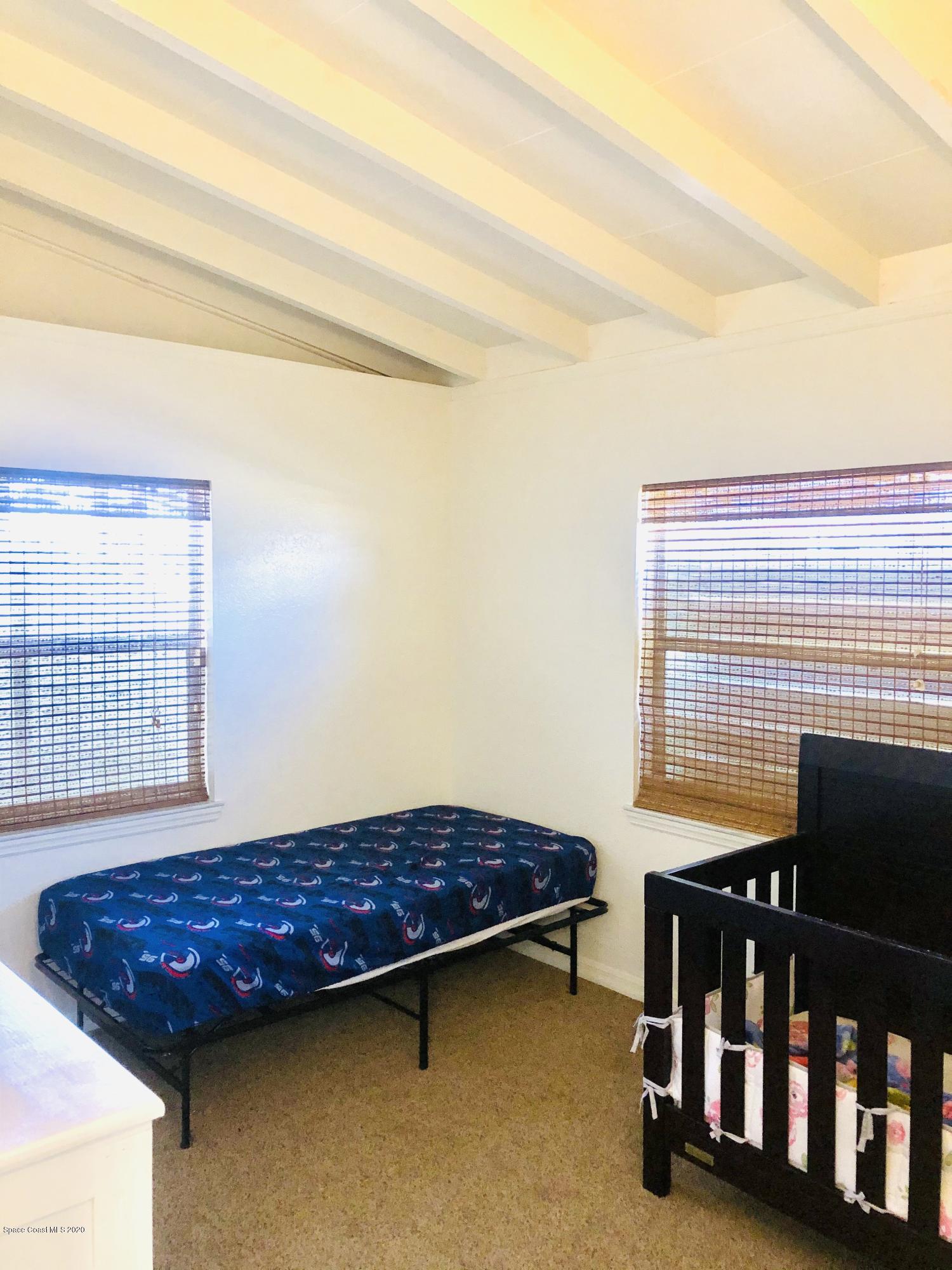 2224 Laden Road Melbourne, FL 32935 - Photo 12 of 26 a bedroom with a bed and two windows