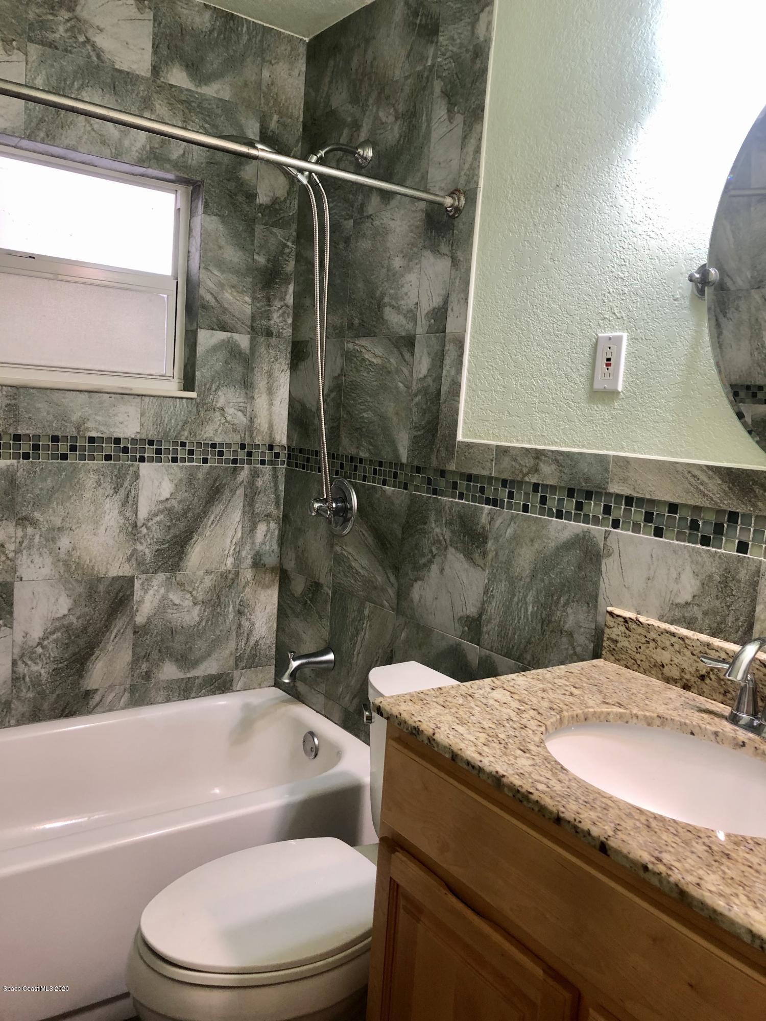 2224 Laden Road Melbourne, FL 32935 - Photo 14 of 26 a bathroom with a granite countertop bathtub shower sink vanity and toilet