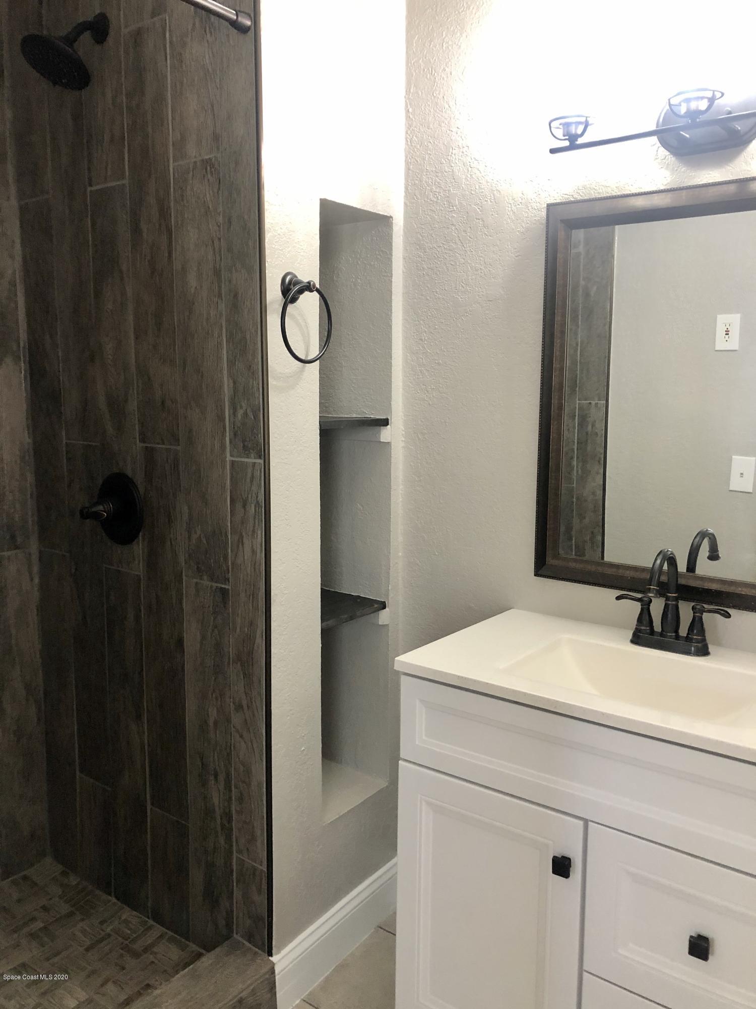 2224 Laden Road Melbourne, FL 32935 - Photo 16 of 26 a bathroom with a sink vanity and mirror