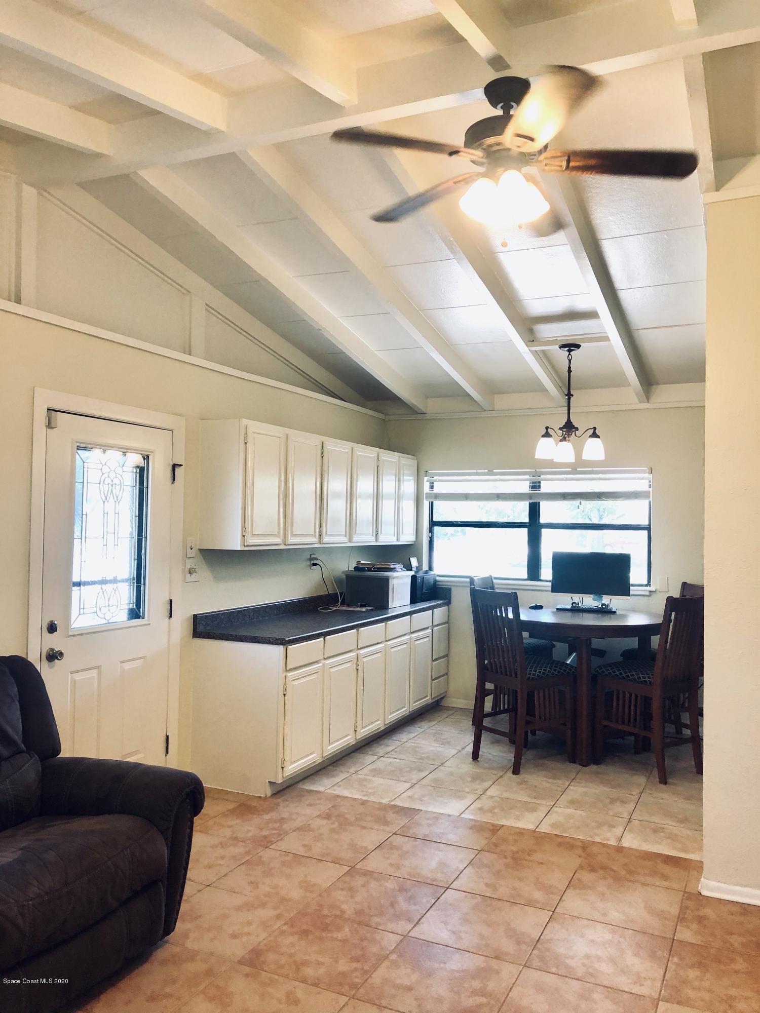 2224 Laden Road Melbourne, FL 32935 - Photo 8 of 26 a kitchen with stainless steel appliances granite countertop a sink dishwasher a stove a dining table and chairs with wooden floor
