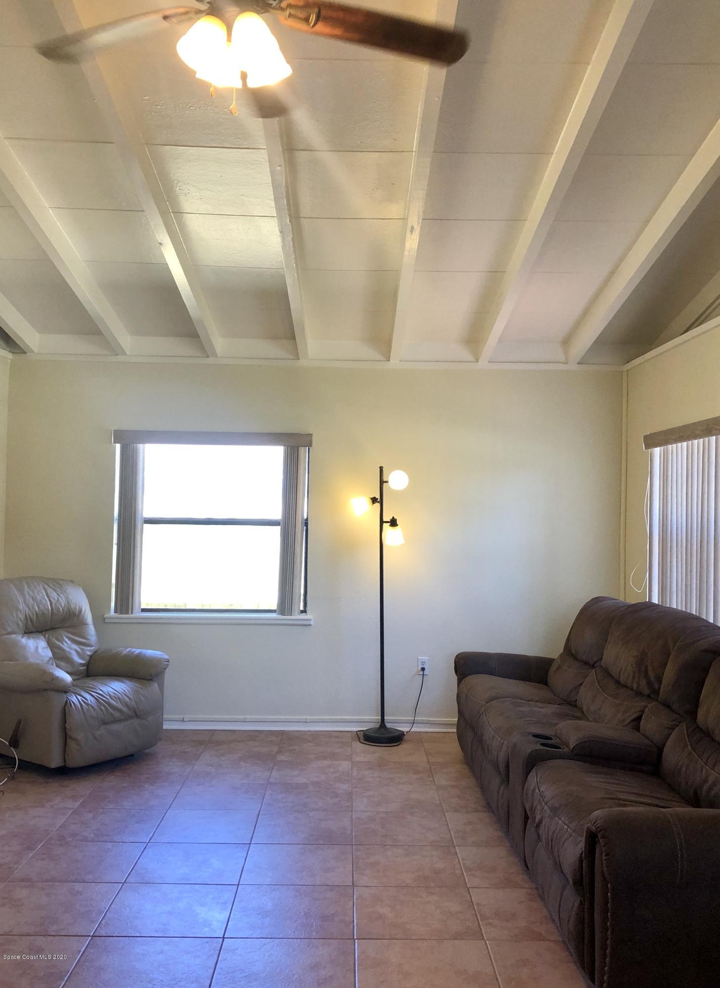 2224 Laden Road Melbourne, FL 32935 - Photo 9 of 26 a living room with furniture a window and a chandelier