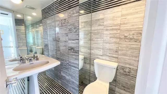 a bathroom with a sink a toilet and shower