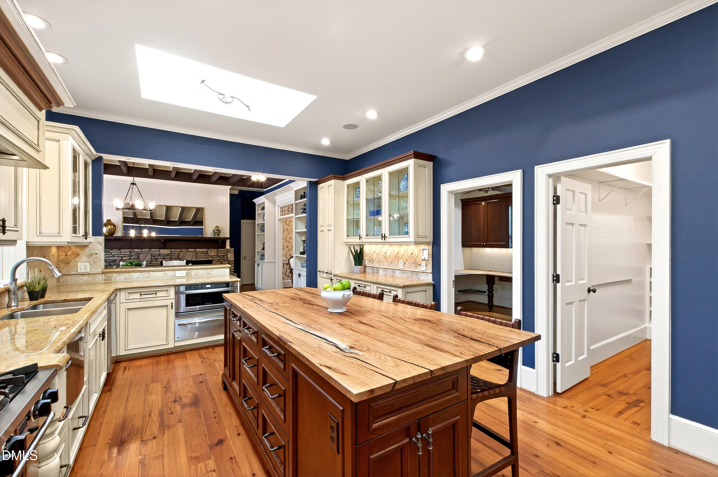 2111 Cook Ridge Court Raleigh, NC 27615 - Photo 28 of 83 a kitchen with stainless steel appliances kitchen island granite countertop a stove a sink dishwasher and a refrigerator with wooden floor