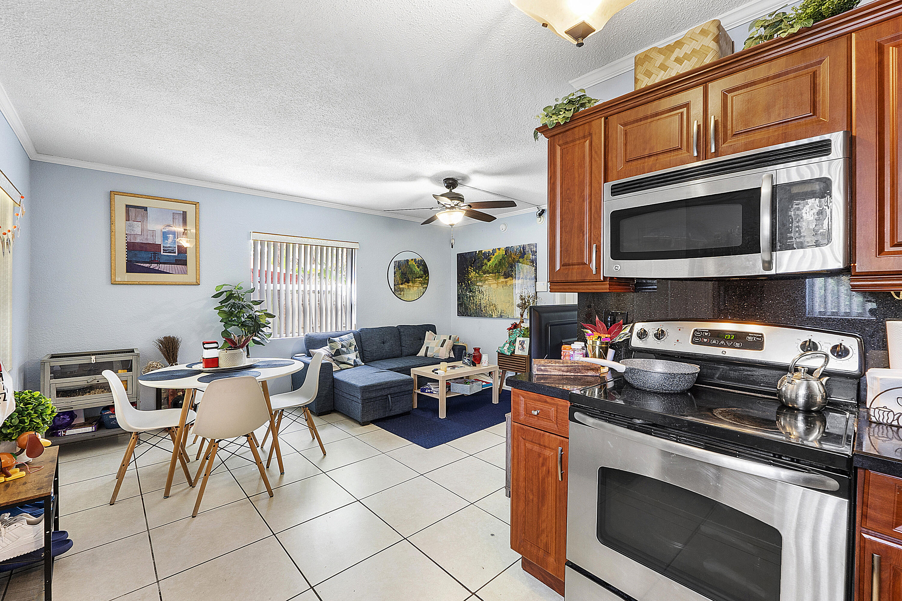 a kitchen with stainless steel appliances a stove a sink a microwave and dining table