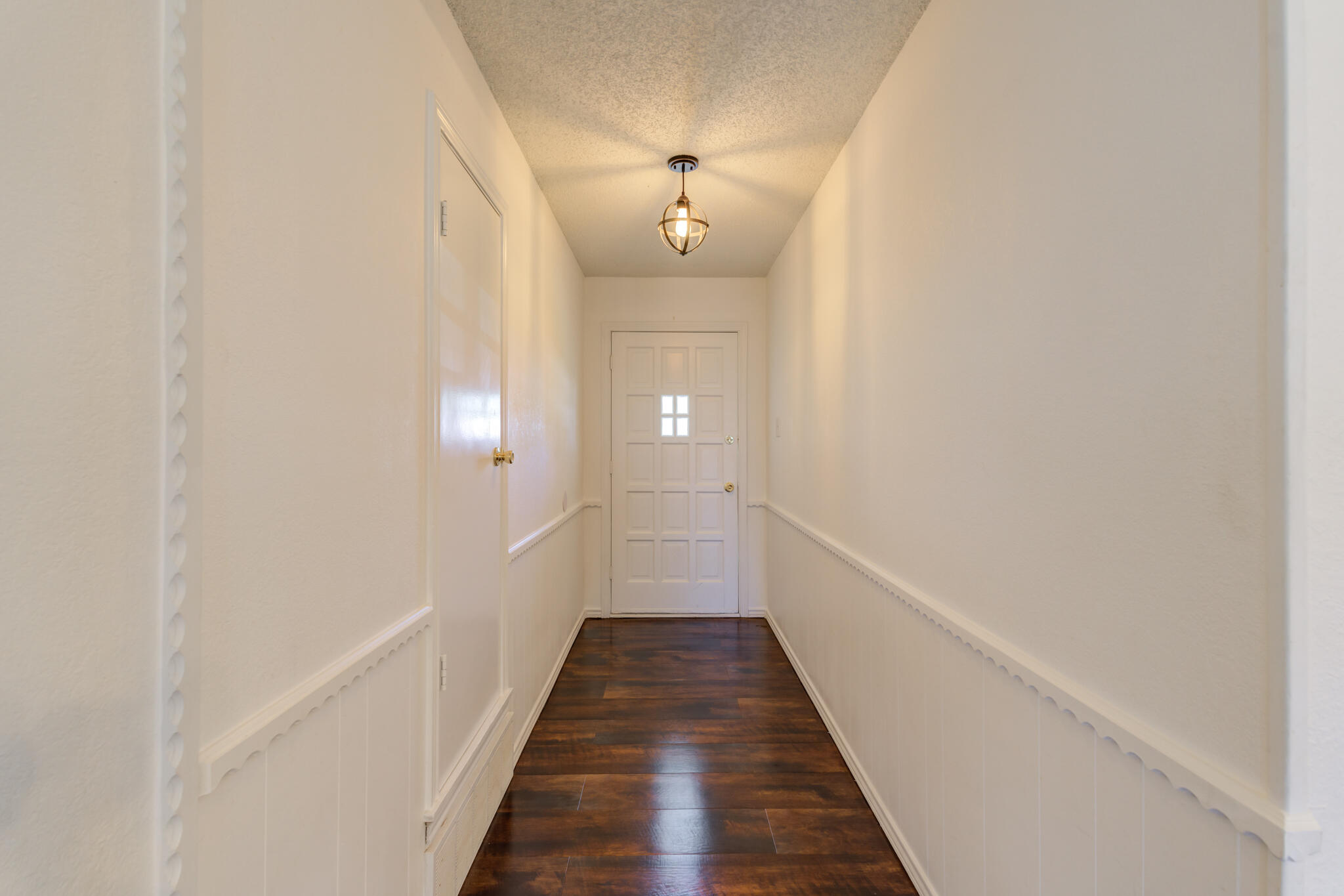 4813 73rd Street Lubbock, TX 79424 - Photo 5 of 37 a view of a hallway with wooden floor and a chandelier