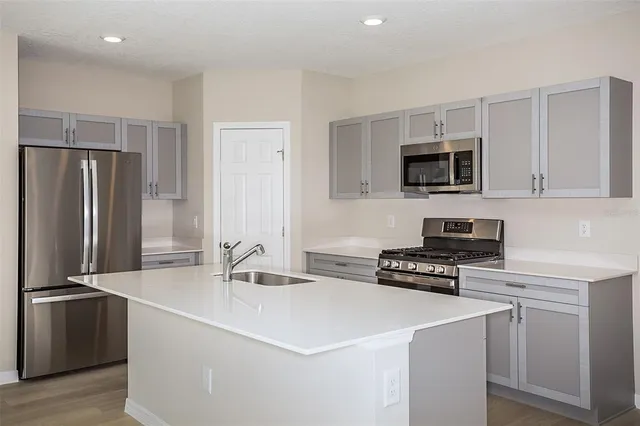 a kitchen with stainless steel appliances a refrigerator stove and microwave