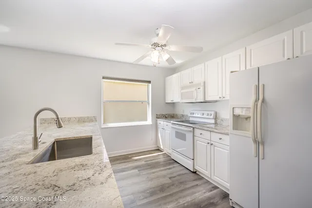 a kitchen with stainless steel appliances a refrigerator sink and white cabinets