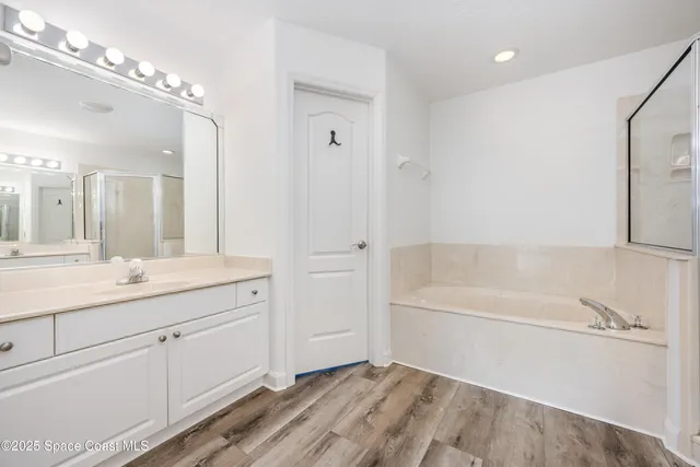 a bathroom with a tub sink and mirror