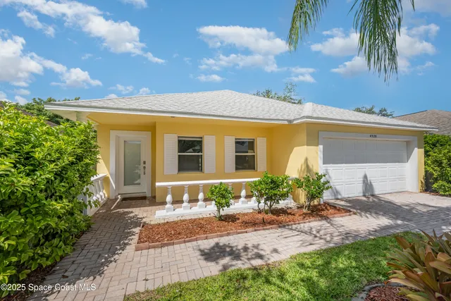 a front view of a house with a yard and potted plants