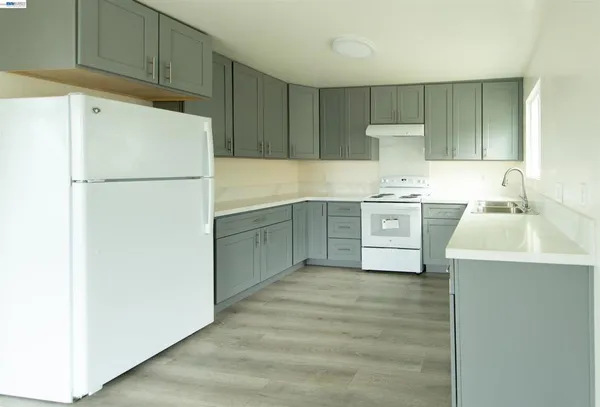 a kitchen with appliances a sink and a refrigerator