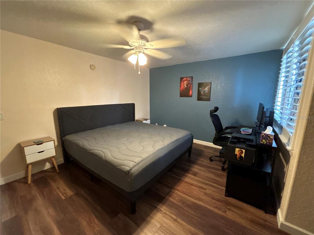 4912 25th Street West, Unit 102 Bradenton, FL 34207 - Photo 11 of 12 a bedroom with a bed and wooden floor