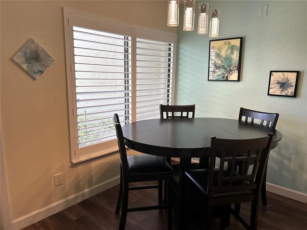 4912 25th Street West, Unit 102 Bradenton, FL 34207 - Photo 2 of 12 a view of a dining room with furniture and wooden floor