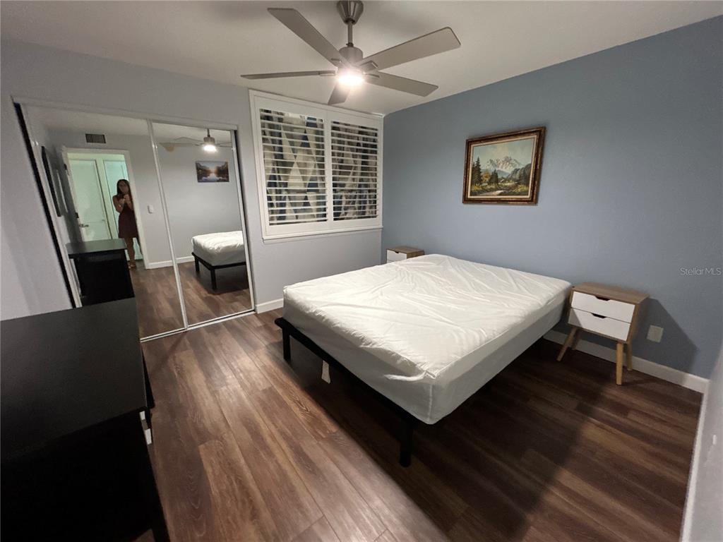 4912 25th Street West, Unit 102 Bradenton, FL 34207 - Photo 7 of 12 a bedroom with a bed a mirror on a dresser and a table