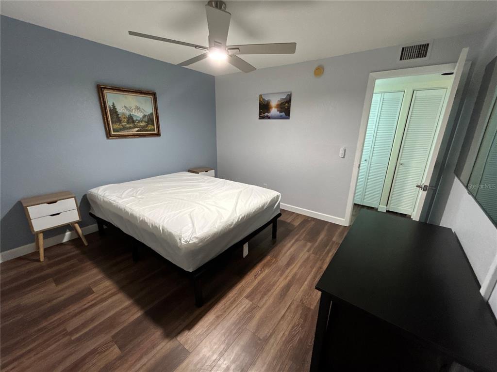 4912 25th Street West, Unit 102 Bradenton, FL 34207 - Photo 8 of 12 a bed sitting in a bedroom next to a window