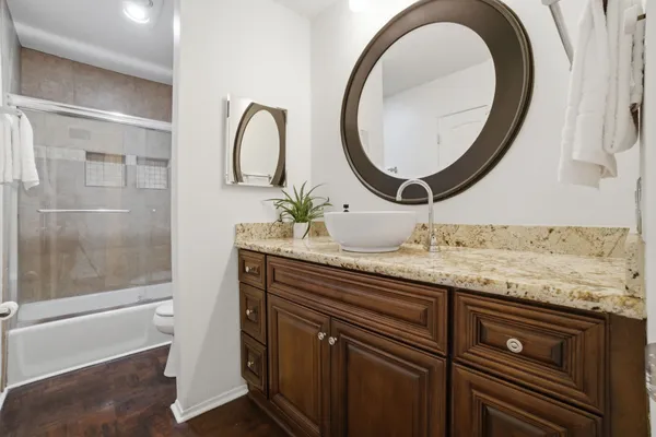 a bathroom with a granite countertop sink and a mirror