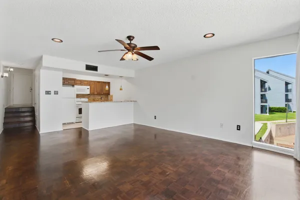 a view of empty room with wooden floor and windows