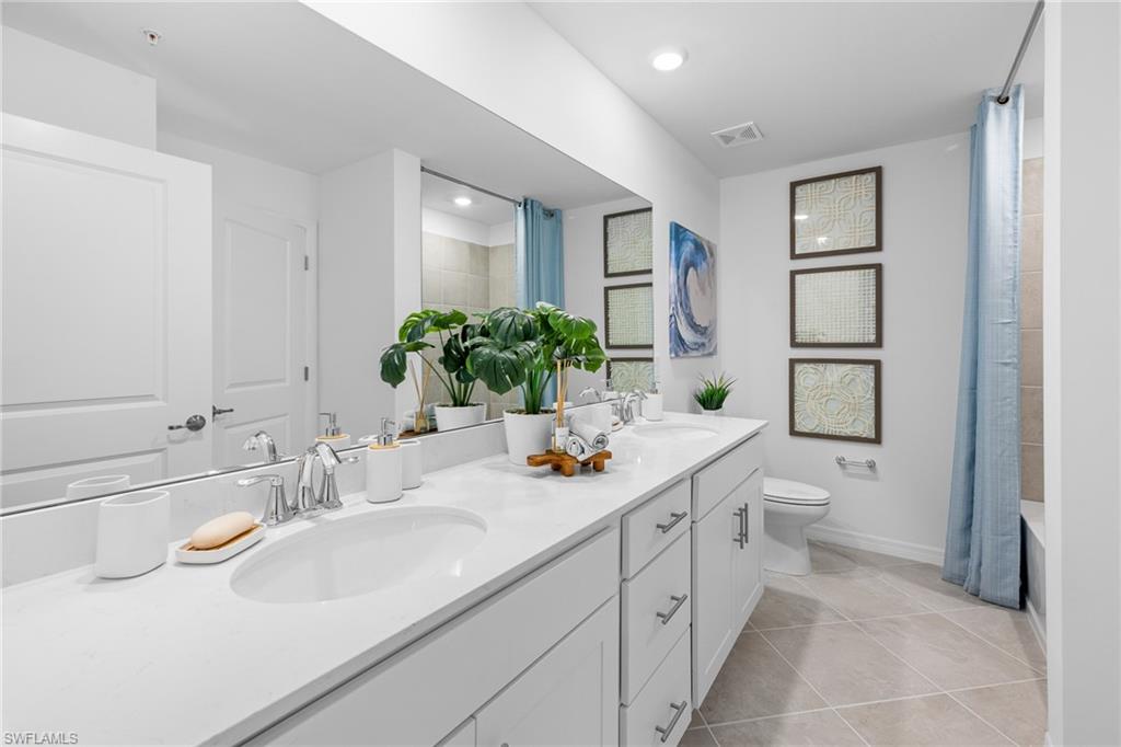 18461 Copperhead Drive, Unit 418 Lehigh Acres, FL 33936 - Photo 15 of 33 Full bath with double vanity, tile patterned floors, shower / bath combo with shower curtain, and recessed lighting