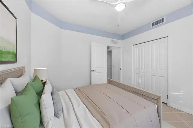 a bedroom with a bed lamp and a potted plant